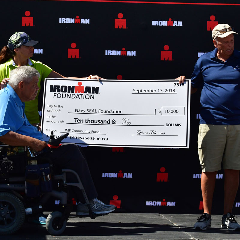 A large check presentation from the Ironman Foundation to the Navy SEAL Foundation for $10,000.