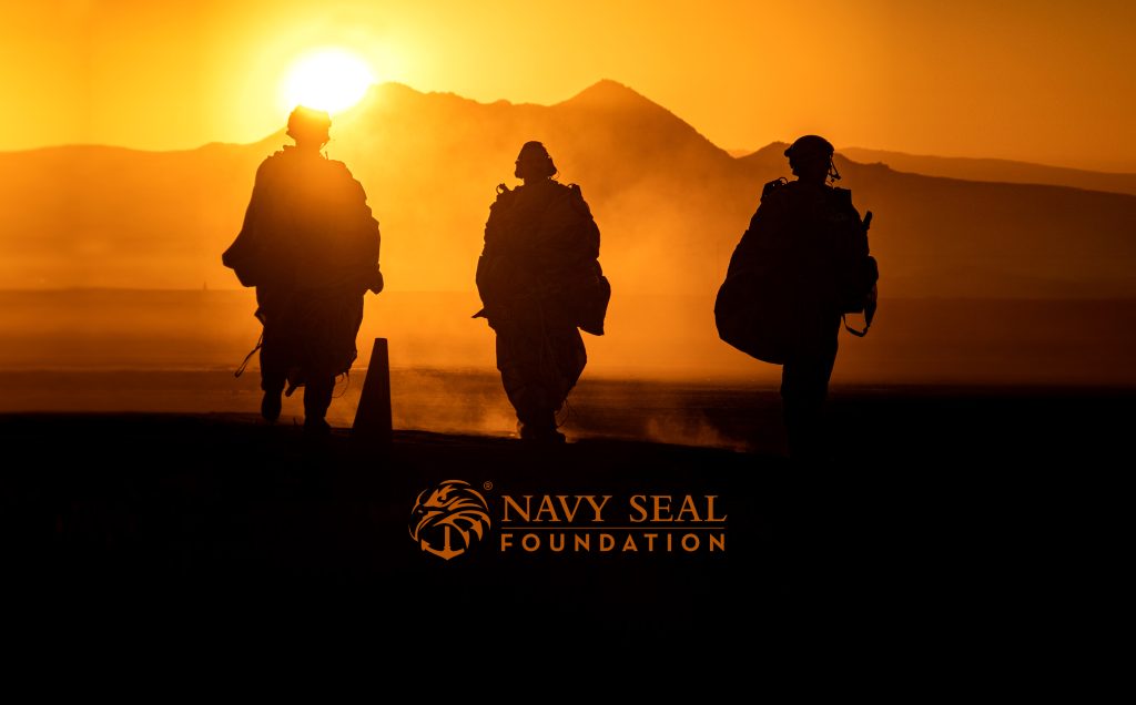 Silhouetted soldiers walking at sunset with the Navy Seal Foundation logo. Navy seal wallpaper is appropriate.